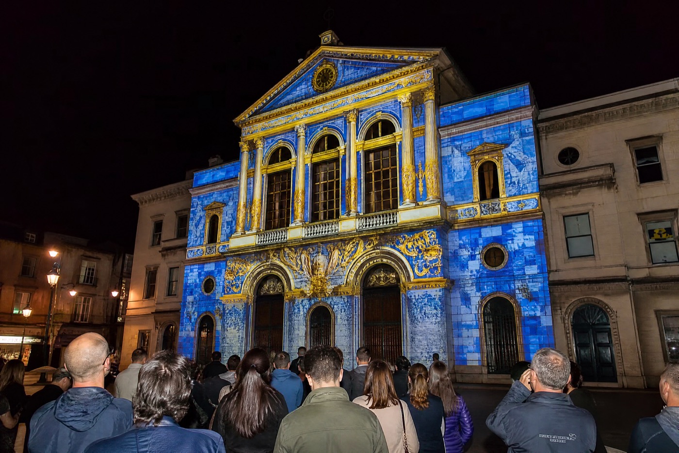 Projection mapping on a church facade in a town square at night